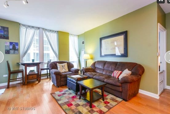 The wood floors of this living room compliment the green walls. 