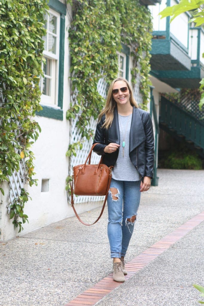 Casey in jeans and black leather moto jacket with wide lapels. 