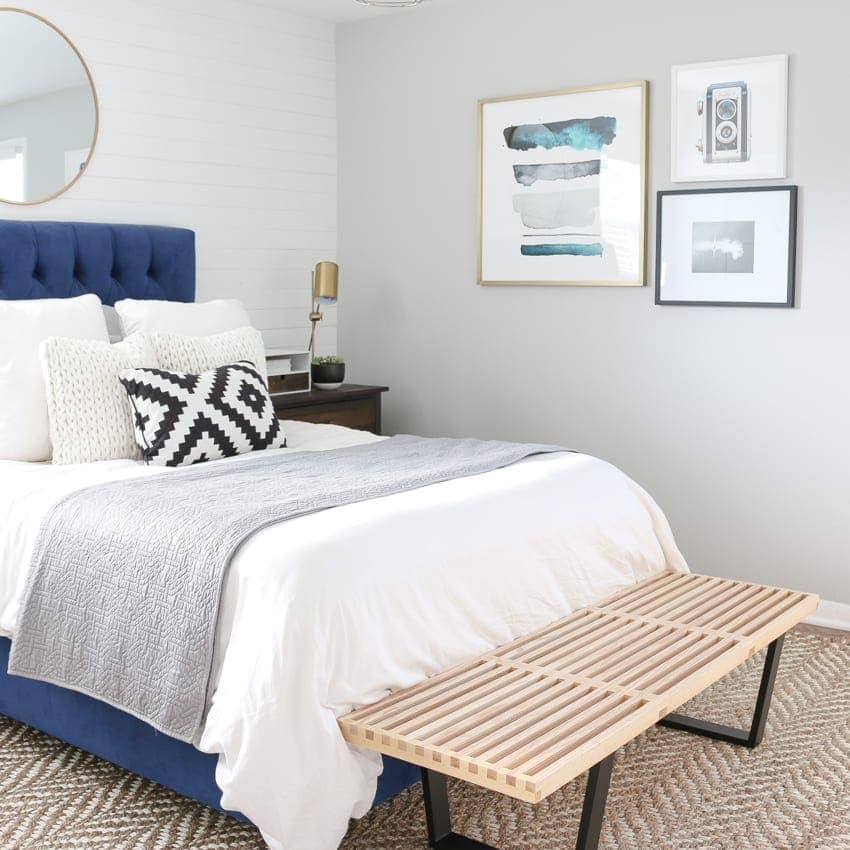 Bright bedroom with soft grey walls and bright blue accents. 