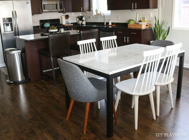 White chairs really brighten up the space around the table in this kitchen. 