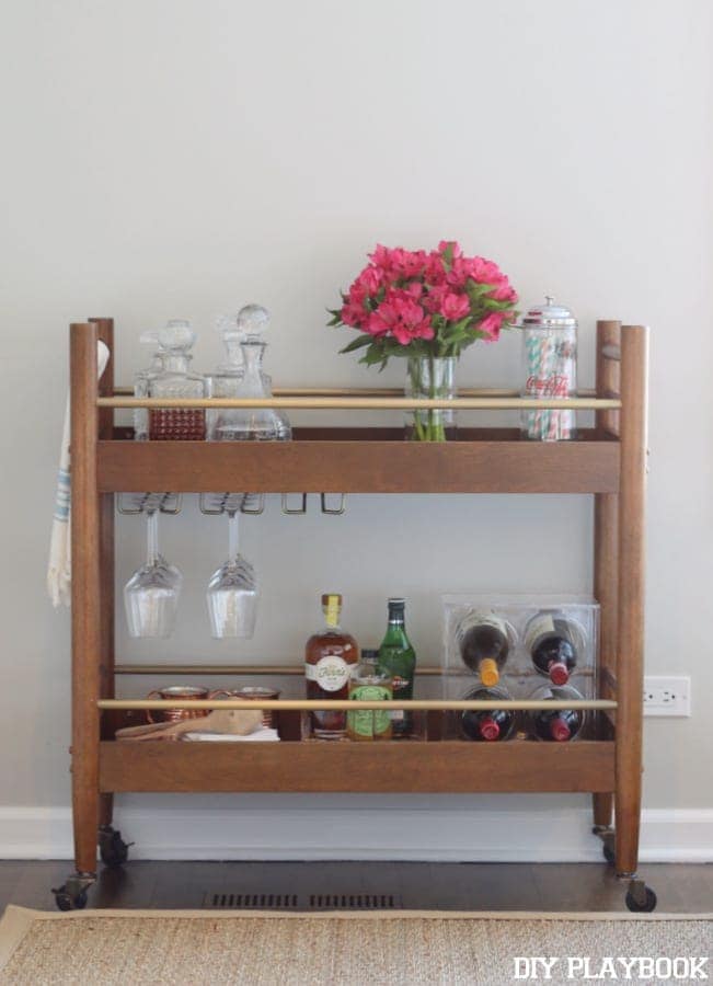 This decorated bar cart adds character to the living room space. 