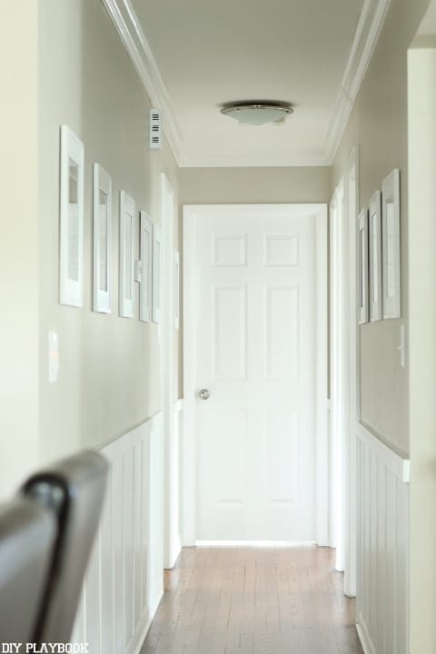 The frames hung in the hallway add to the style of the home. 