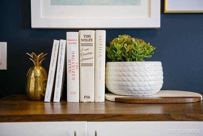 This white planter and gold pineapple decor piece pair well against the wood. 