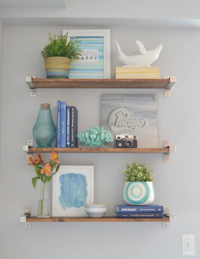 Stylish shelves with books and pops of blue and turquoise are the perfect touch to any room.