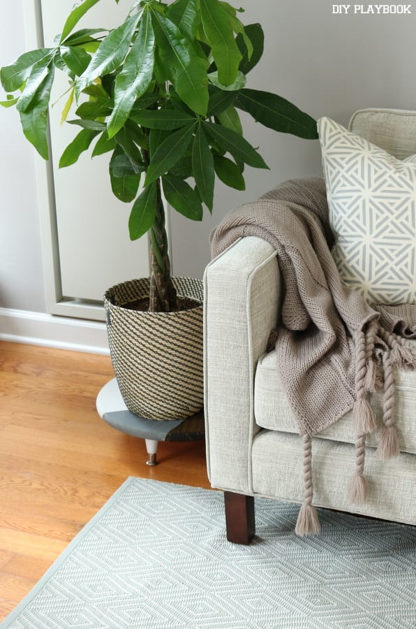 This chic plant stand matches the decor of the room.