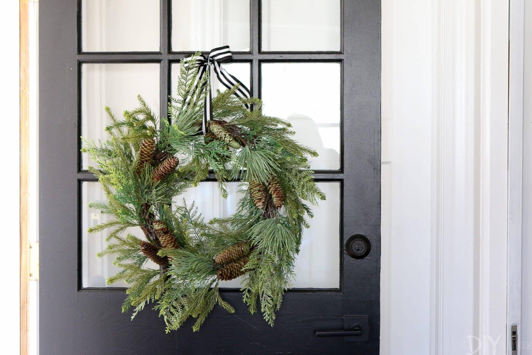 This black windowpane door is really dressed up for the holidays with a simple pine bough wreath. 