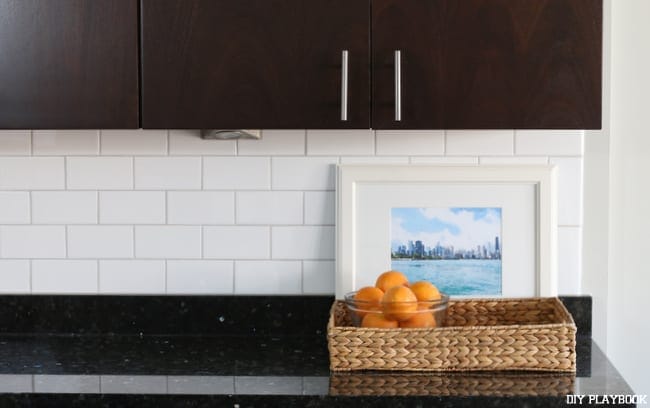 White Subway Tile Backsplash was exactly what our kitchen needed to compliment the dark countertops and dark kitchen cabinets. | DIY Playbook