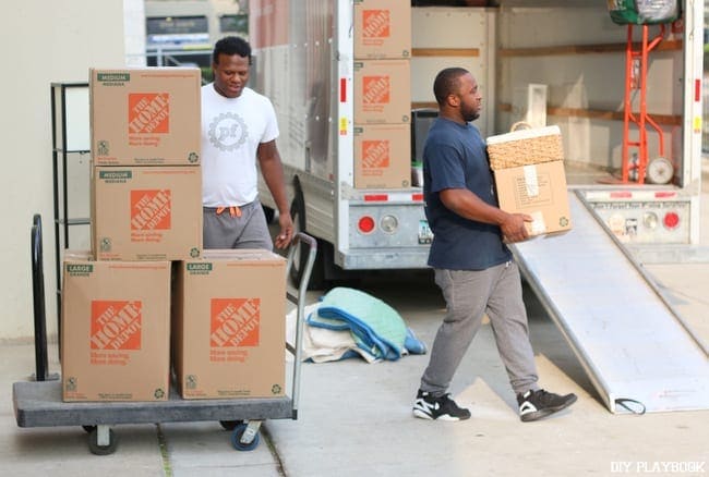 Professional movers transport boxes into the U-Haul. 