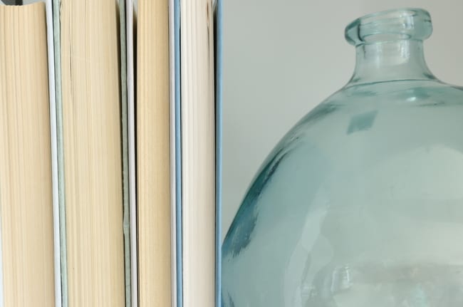 Decorative books and glass jar on the built-in bookshelf. 