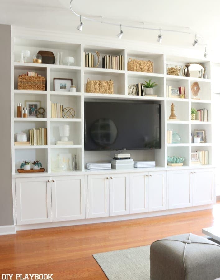 Built-in bookshelf and entertainment center styled with thrifted home accessories. 