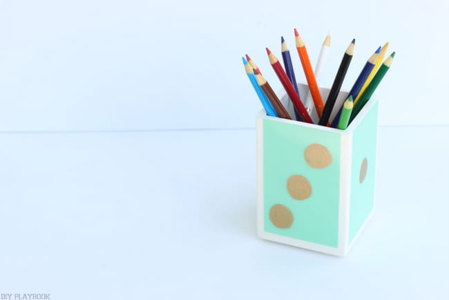 Recreate the face of a die on this simple pencil holder with a gold paint marker