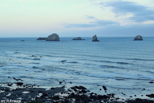 Pacific Ocean views with waves, shoreline rocks, and sunset clouds along Highway 101 from our Seattle to San Francisco road trip.