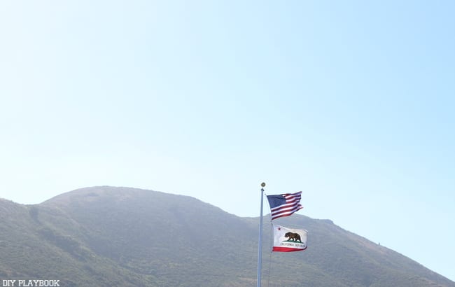 Entering California! The California flag flies high alongside the American flag as we arrive in Cali during our Seattle to San Francisco road trip.