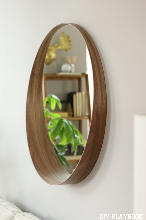 A round mirror on a soft grey wall looks great in this condo revamp. 