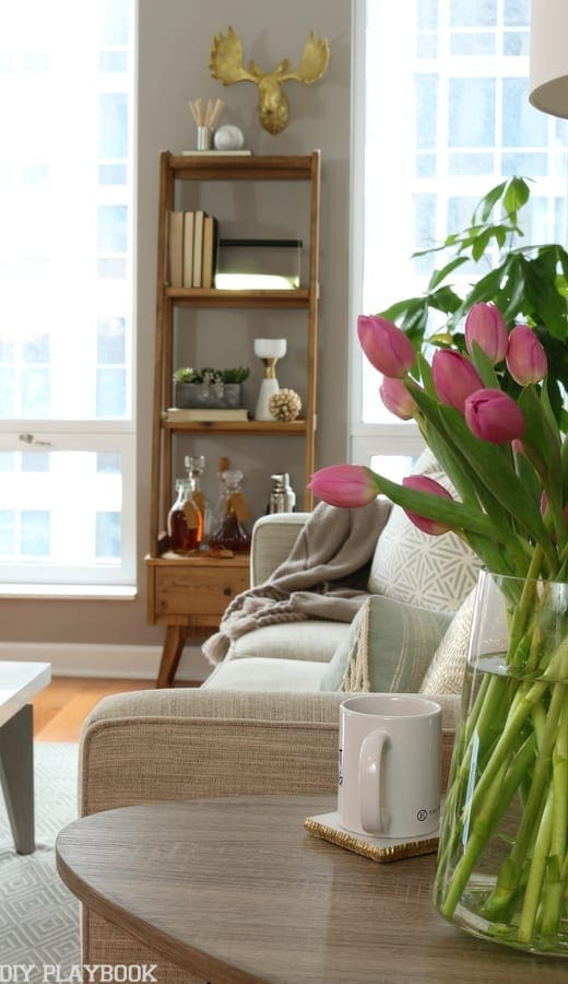 The shelf adds height between the two beautiful bright windows in this condo living room. 