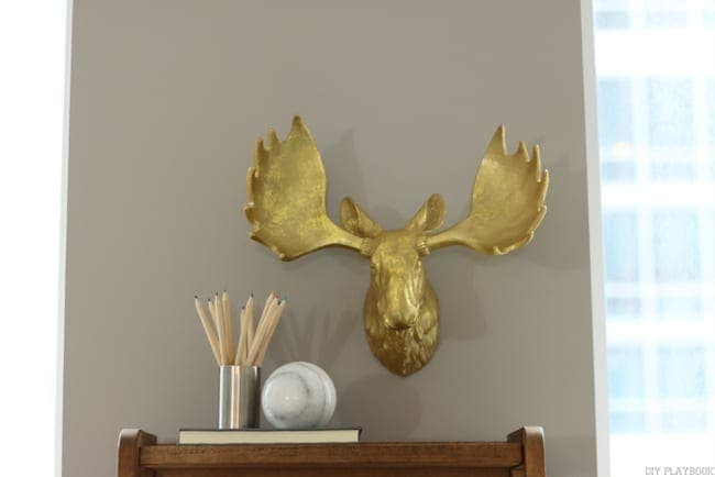 Fun golden moose head adds personality to this grey wall and condo update. 