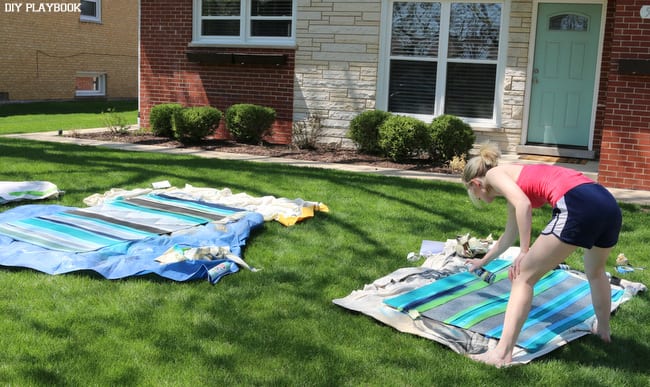 DIY Outdoor Painted Rug - painting in progress! Here's Bridget pray painting our outoor rugs. 