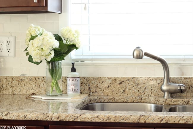 Beautiful flowers brighten up the room against the new kitchen backsplash. 