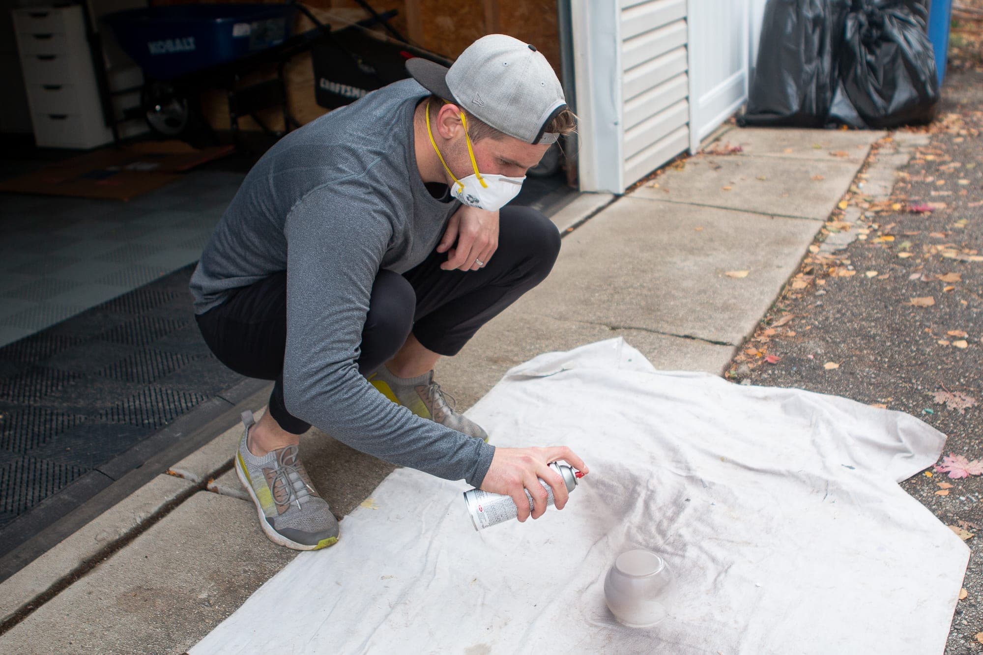 Finn using chalk spray paint on a vase. 