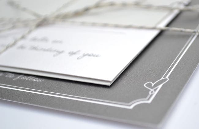 A simple cursive heart on the corner of the wedding invitations