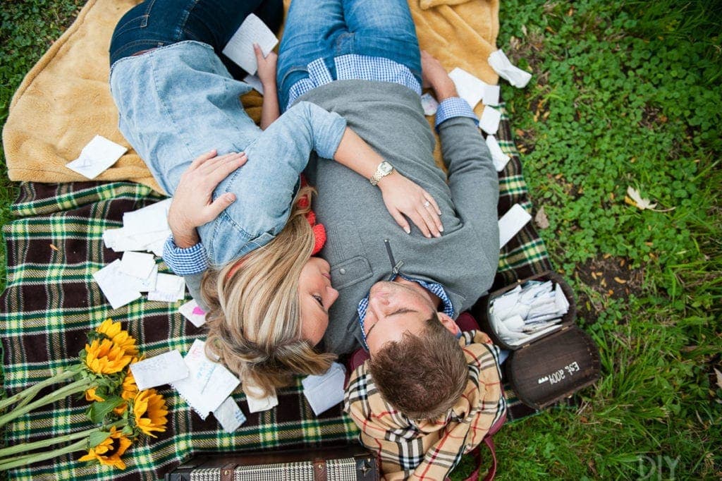 Surrounded by love letters in an engagement photo shoot