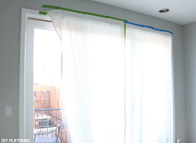 Bedroom with curtains taped to the windows as the makeover was in progress. 