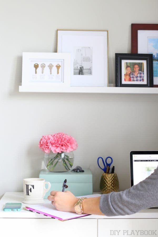 Floating shelves above a small bedroom desk and work space. 