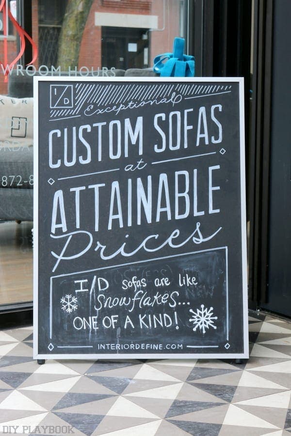 The sign outside of Interior Design reads: Exceptional Custom Sofas at Attainable Prices. 