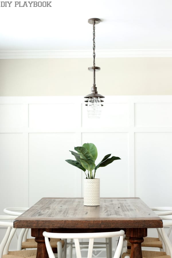 Dining room with overhead pendant light and board and batten walls. 